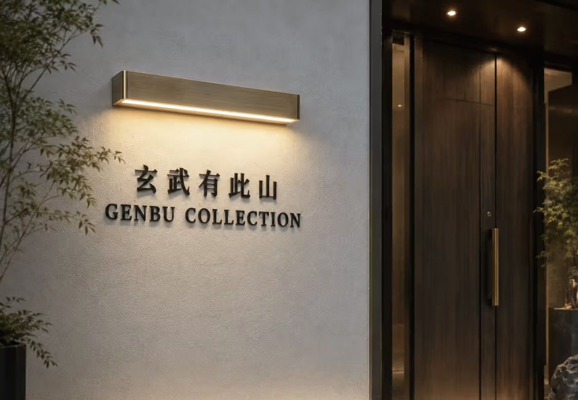 夜色中的玄武有此山门头，暖光灯带照亮墙上的招牌